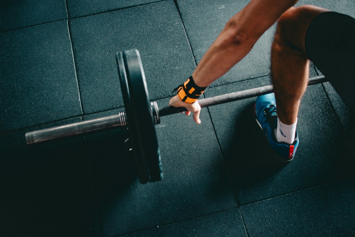 Persona che si allena sollevando un bilanciere in palestra